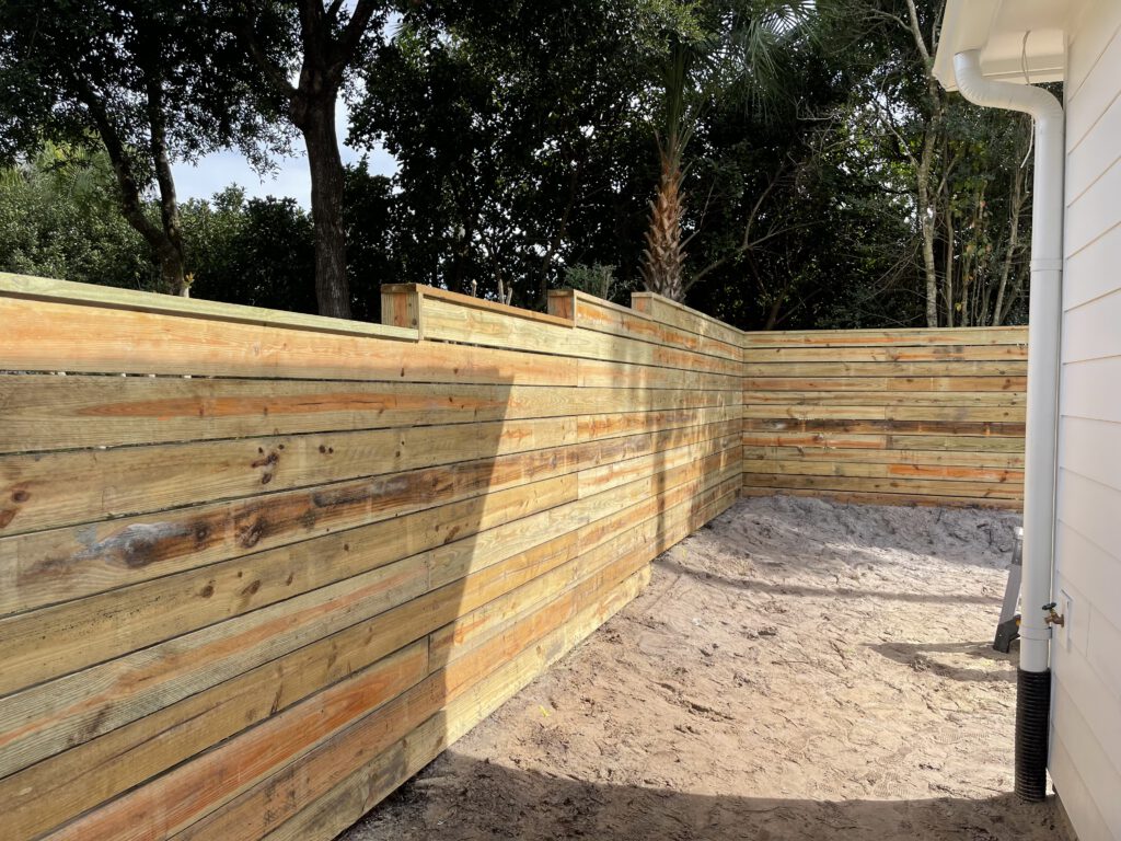 New horizontal fence panel and posts along a property line