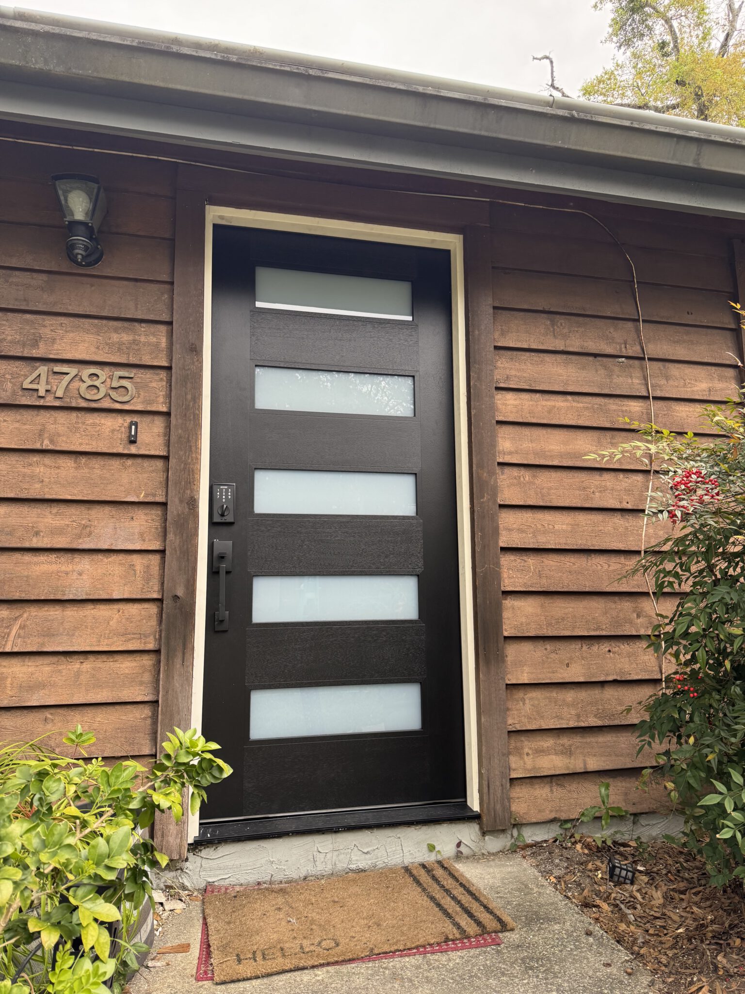 New modern entry door set into cedar shake siding